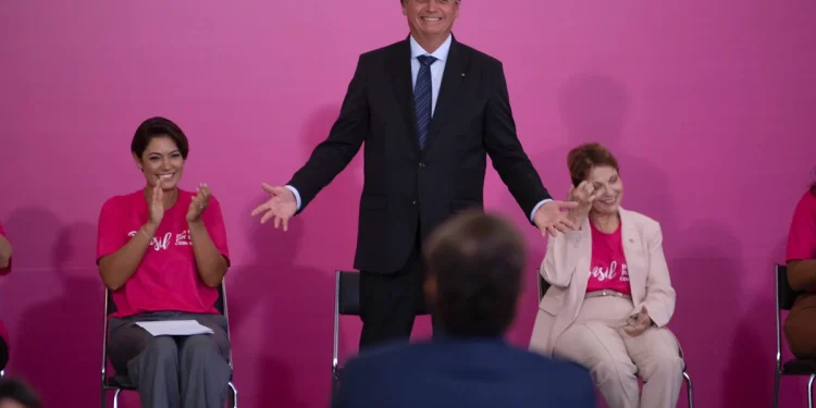 A primeira-dama Michelle Bolsonaro, o presidente Jair Bolsonaro e a ministra Tereza Cristina acenam para a plateia. Bolsonaro
